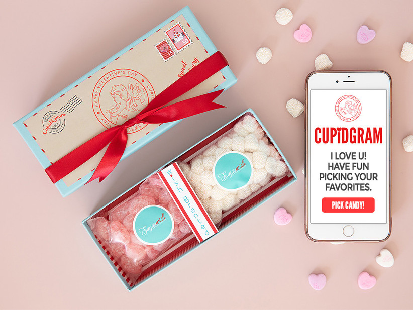 Mobile phone showing Valentine's candy-gram next to box of candy