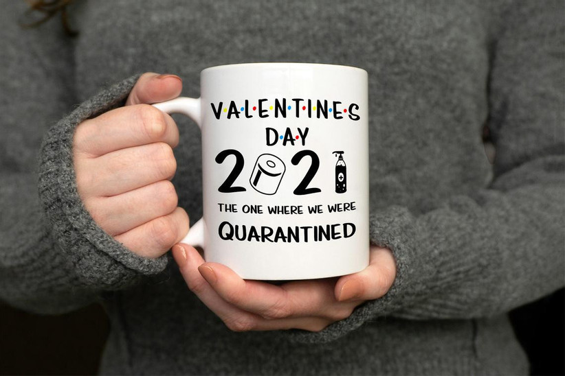 Close up of person holding white Valentine's Day mug with quarantine theme