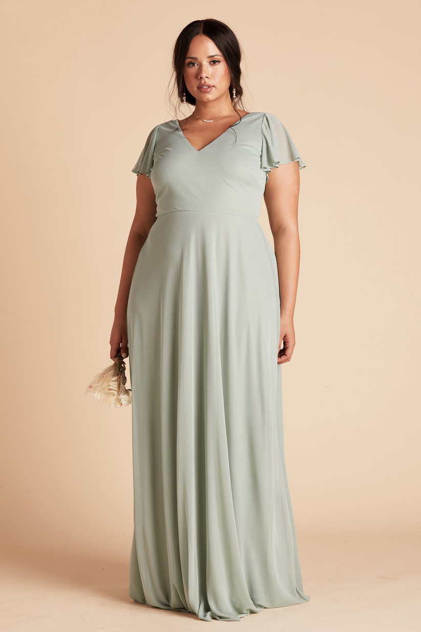 Model wearing simple sage green pastel bridesmaid dress with flowy chiffon skirt and short sleeves