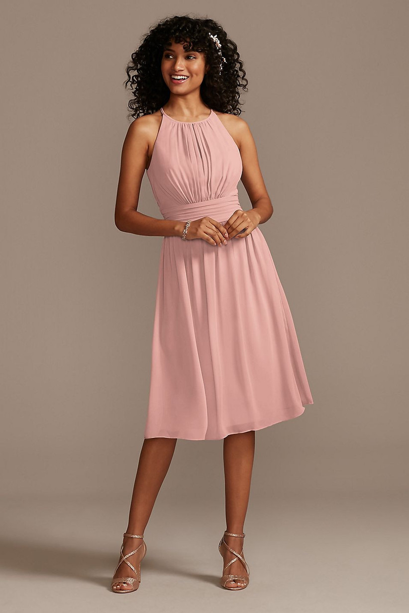 Model wearing short pastel pink bridesmaid dress with pleats