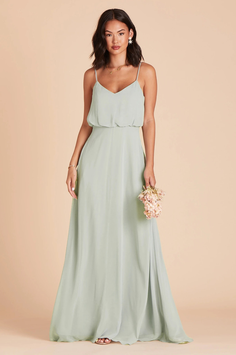 Model wearing minimalist pastel green bridesmaid dress with blouson bodice and flowy chiffon skirt
