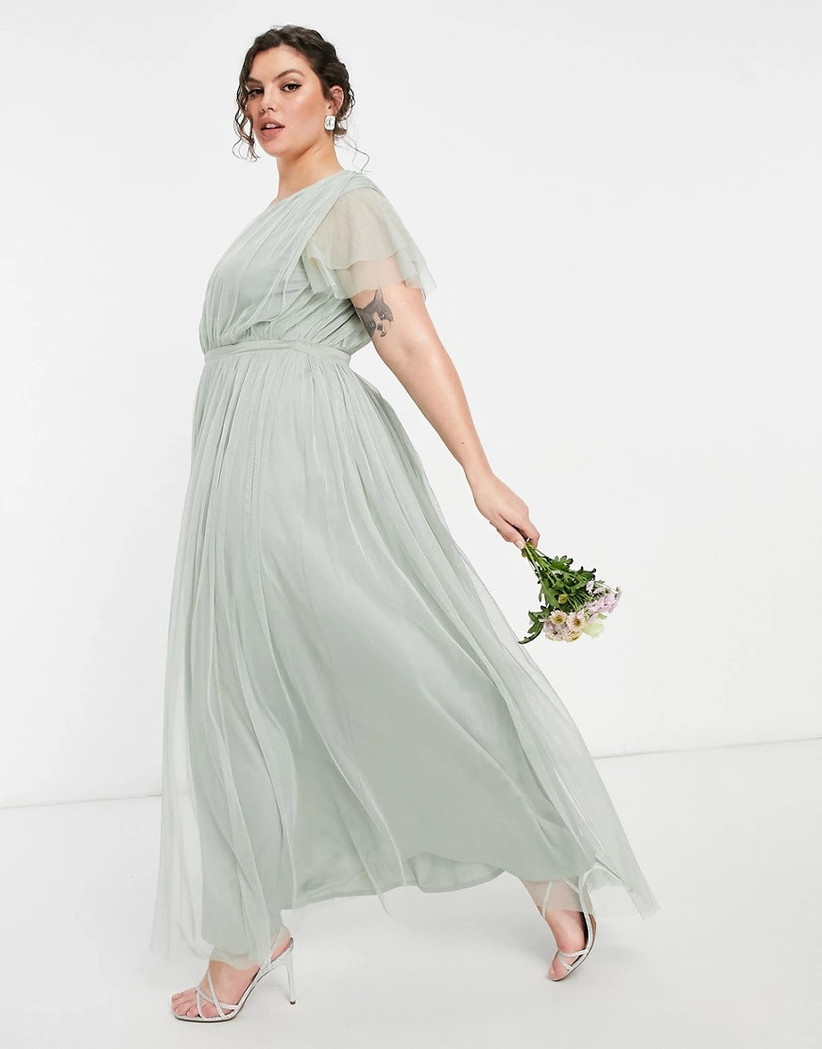 Model wearing sage green chiffon bridesmaid dress with sheer ruffled sleeves