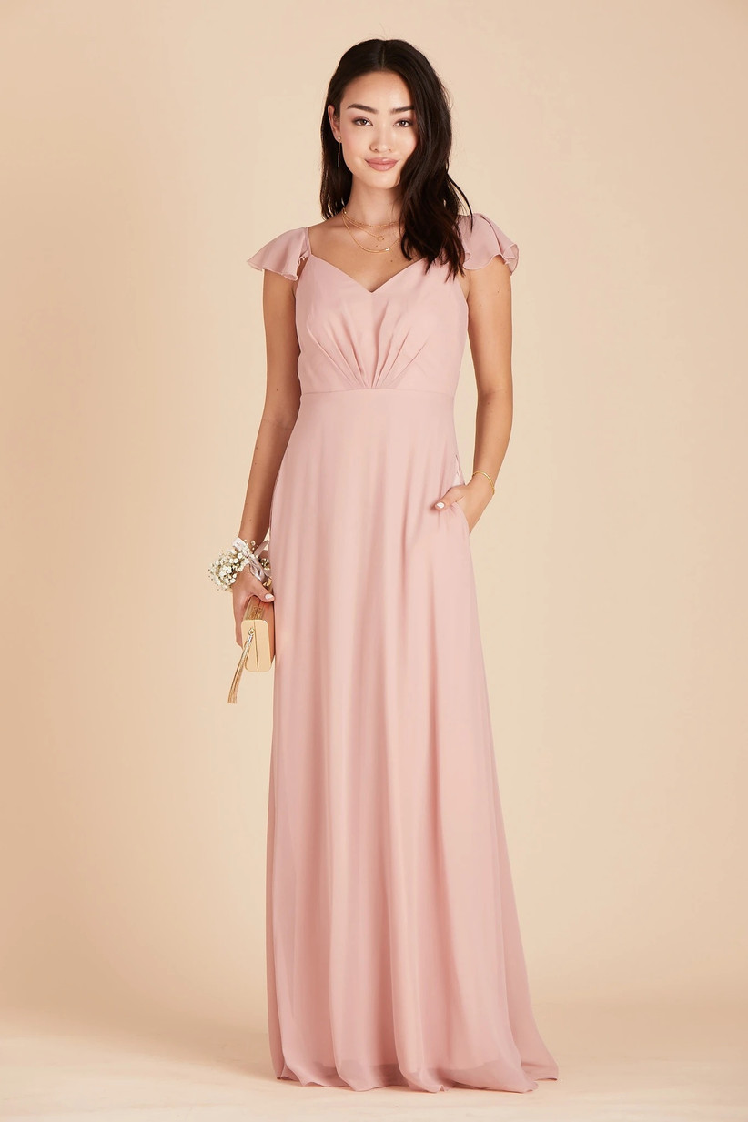 Model wearing cute pastel pink bridesmaid dress with hand in pocket