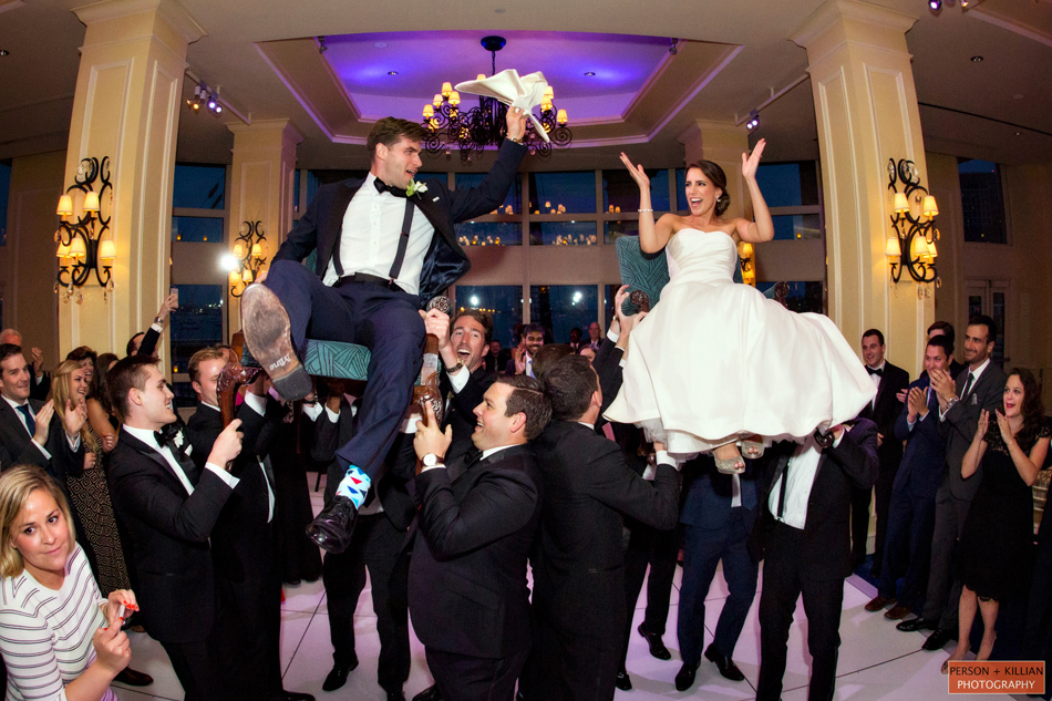 Руководство по составлению расписания свадебного приема |  Пара поднялась в воздух на стульях для еврейского танца Hora Dance.