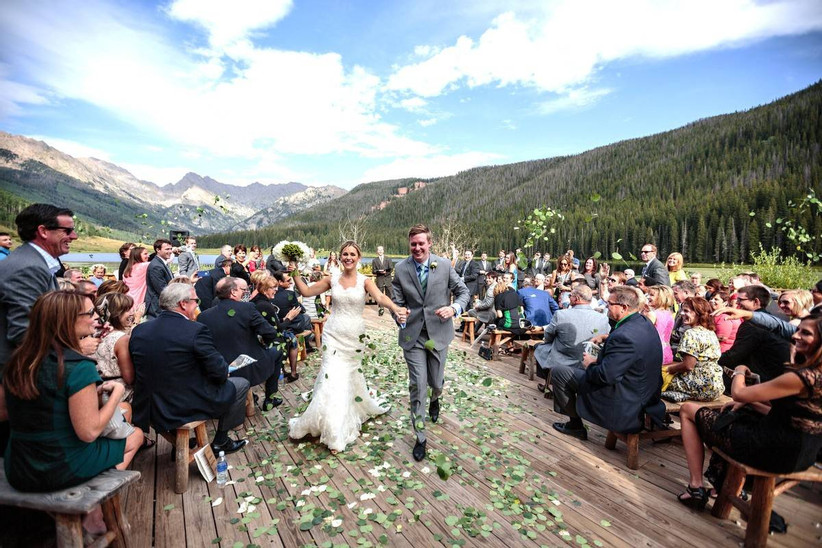 couple exiting wedding ceremony with mountain backdrop