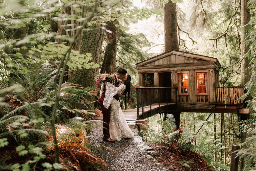 wedding couple kissing next to treehouse