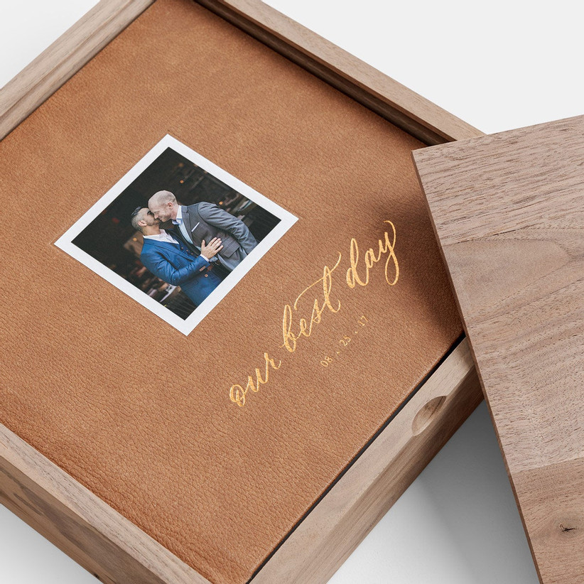Свадебная фотокнига в коричневой кожаной обложке с небольшой фотографией и надписью «Наш лучший день» золотой фольгой.
