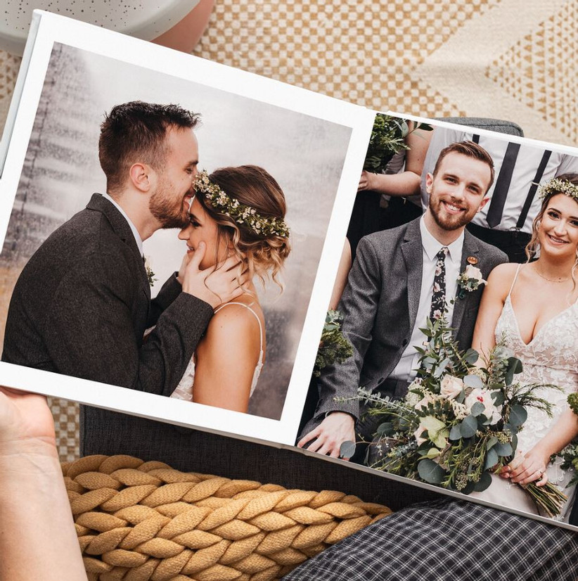 Крупный план человека, смотрящего на свадебную фотокнигу, открыт, чтобы показать две страницы с разными портретами пар 