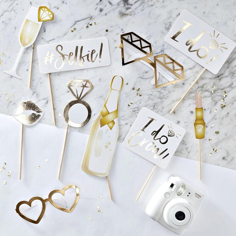 Spread of bachelorette party photo props with white and gold design