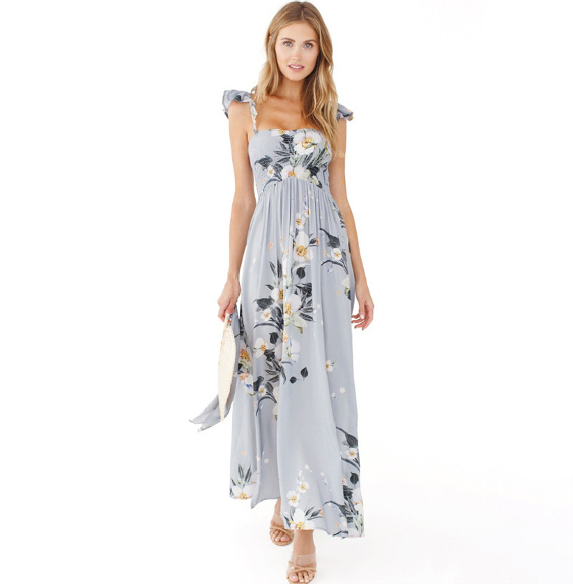 Model wearing floaty light blue maxi with white and green floral print