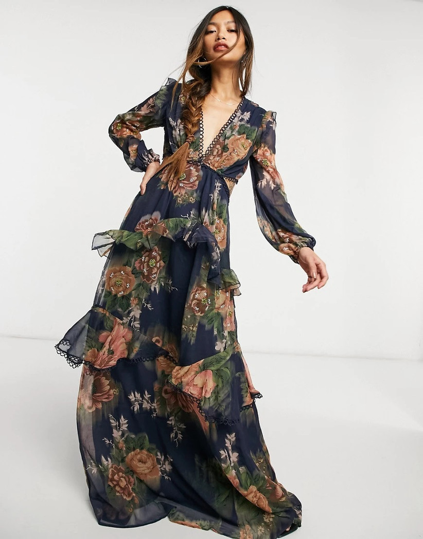 Model wearing navy maxi with ruffled tiers and terracotta floral print