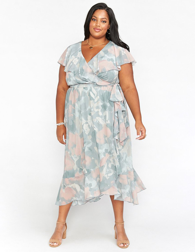 Plus-size model wearing midi-length ruffled pastel dress with abstract floral pattern