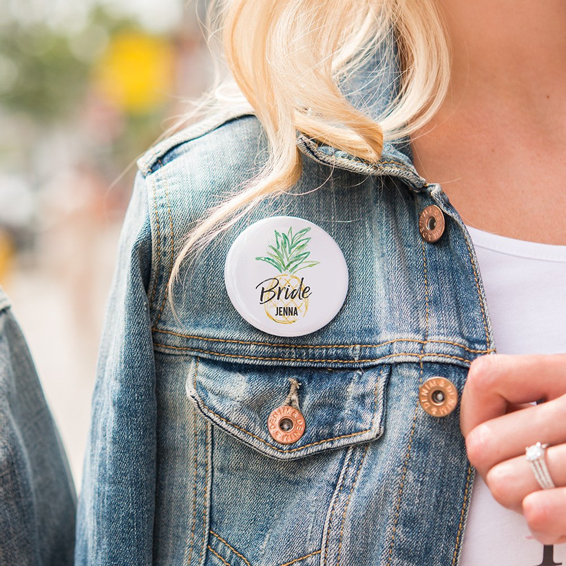 Close up of personalized pineapple motif pin on woman's denim jacket