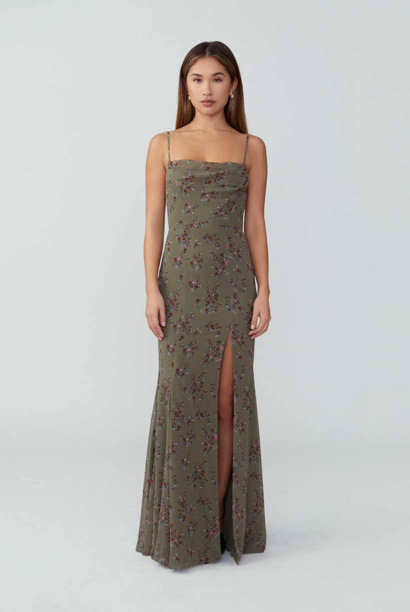 Model wearing minimalist sage green floral spaghetti strap dress with leg slit