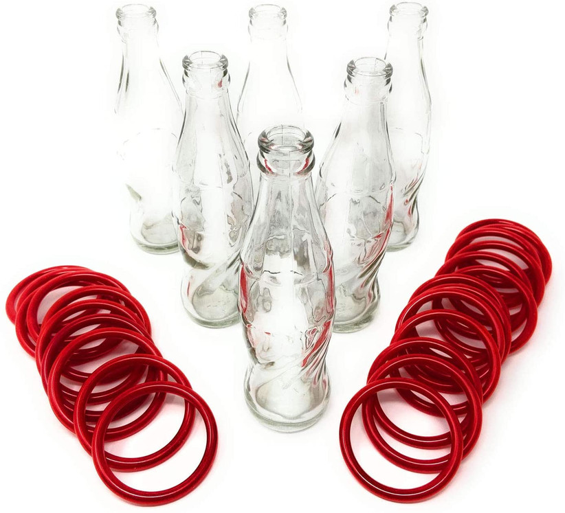 игра в бросание бутылок со стеклянными винтажными бутылками содовой и красными пластиковыми кольцами