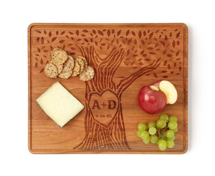 Custom engraved wooden serving board with a couple's initials carved into a tree design with meaningful date