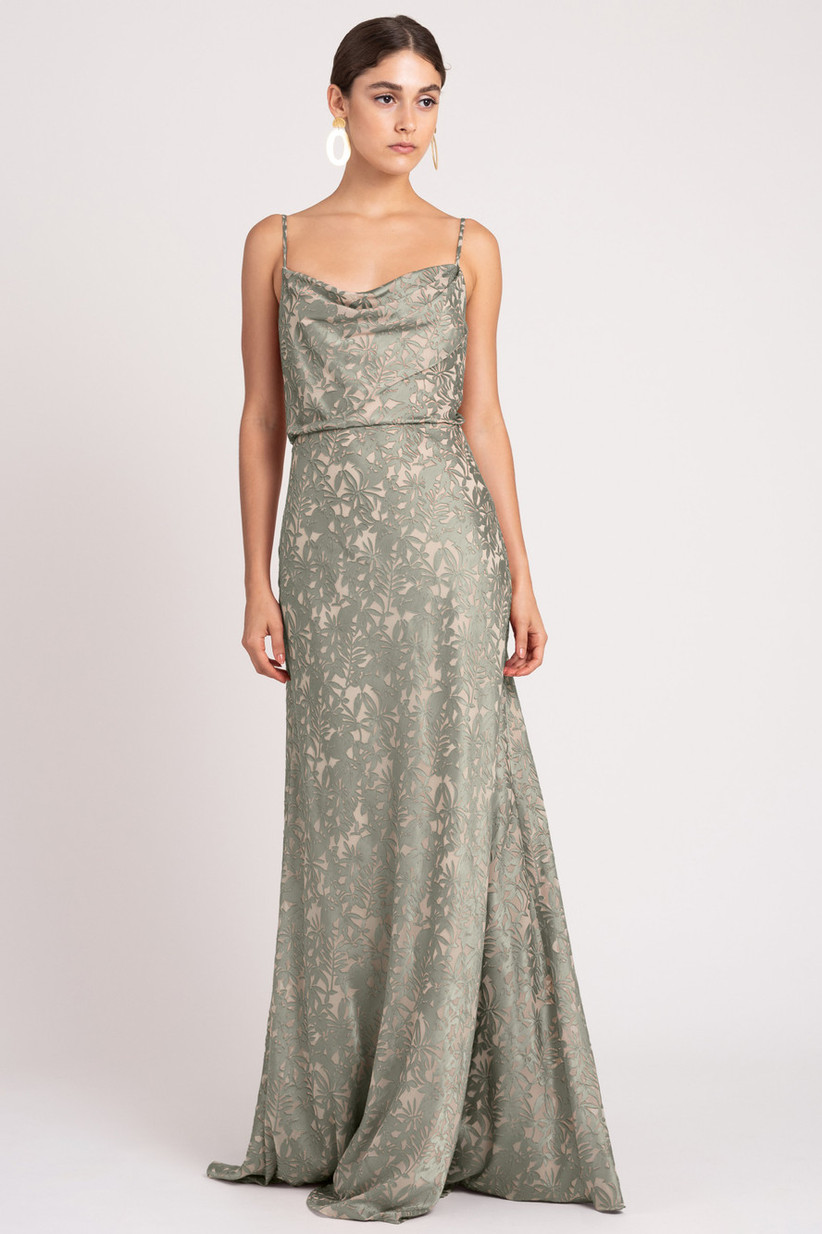 Model wearing elegant sage green mermaid gown with burnout satin creating an abstract floral pattern