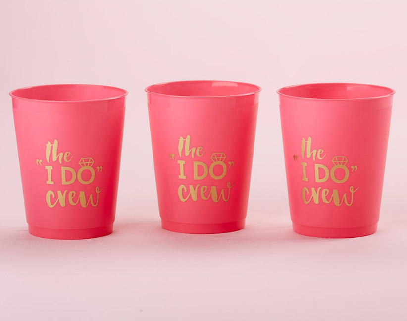 Three pink stadium cups in a row with The I Do Crew in gold lettering