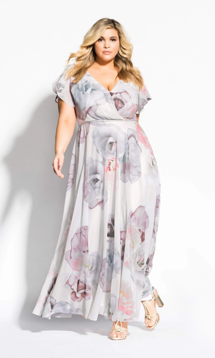 Plus-size model wearing muted pastel bridesmaid dress with large floral print