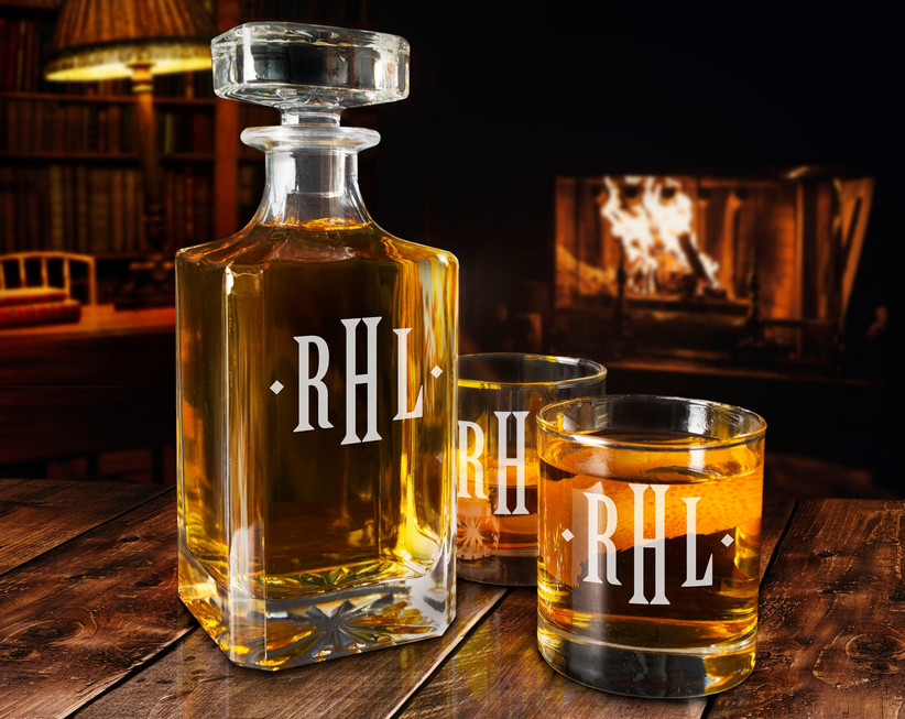 Monogrammed whiskey decanter with two glasses staged in front of a cozy fire