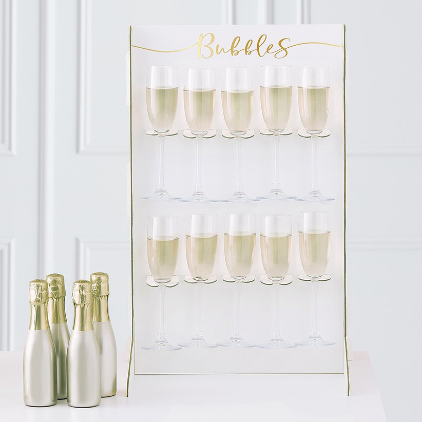 Champagne wall holding ten glasses of bubbly with Bubbles written in gold lettering at the top