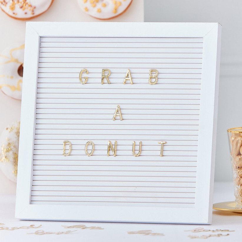 White peg letter board that reads Grab a Donut in gold letters