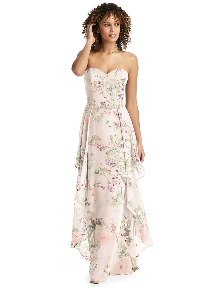 Model wearing light and airy bridesmaid dress with layered skirt and strapless sweetheart neckline in blush pink floral pattern