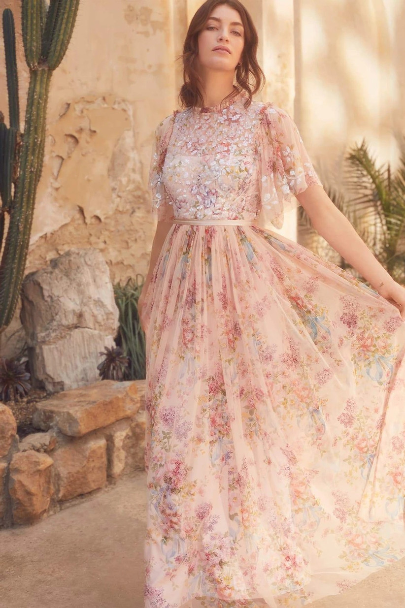 Model posing in vintage pink tulle floral bridesmaid dress with sequined bodice