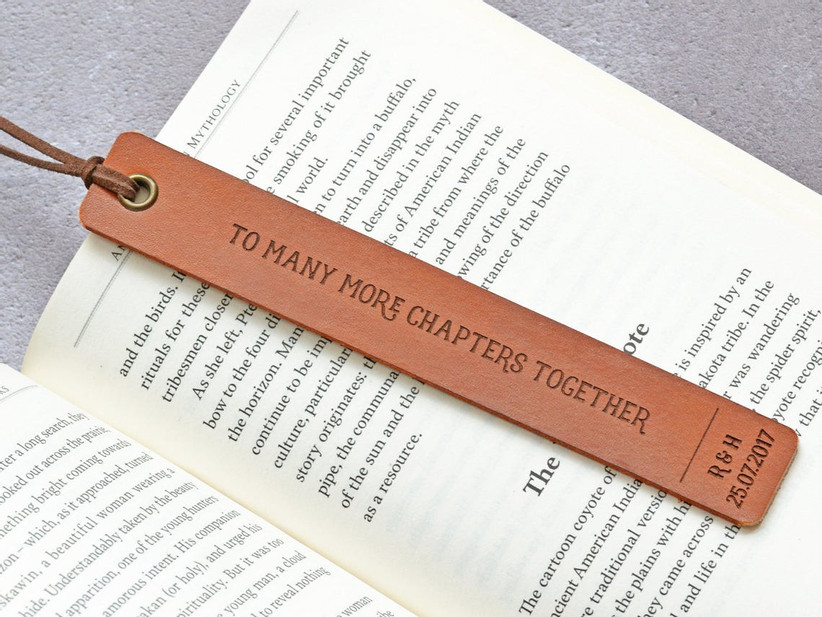 To Many More Chapters Together leather bookmark pictured on the page of an open book