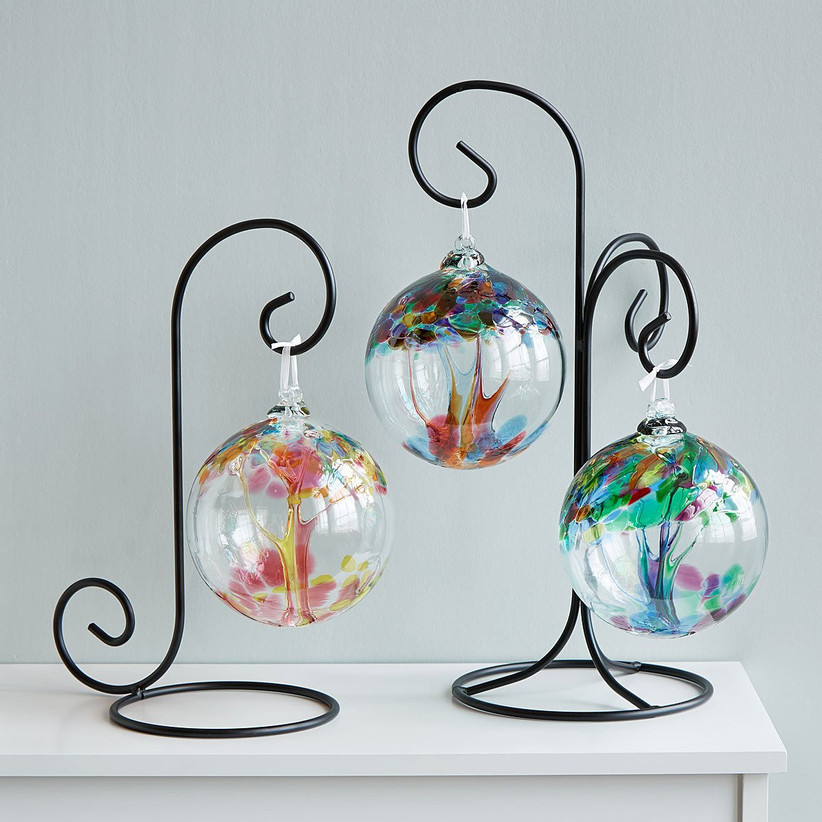 Three colorful glass orbs hanging from ornamental black structure