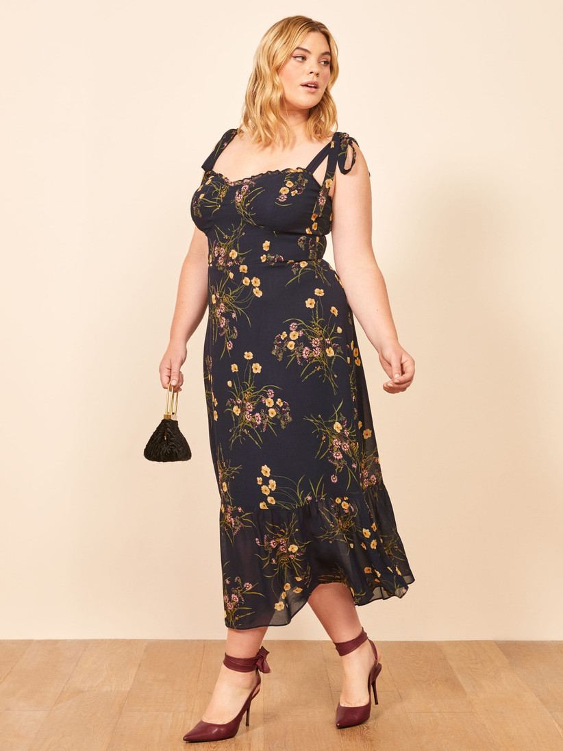 Plus size model wearing black midi with tie-at-the-shoulder straps, pretty wildflower print, and sweetheart neckline