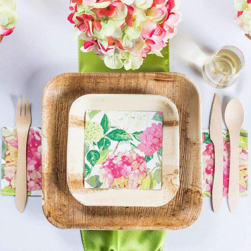 Bright floral place setting with rustic palm leaf plates and cutlery
