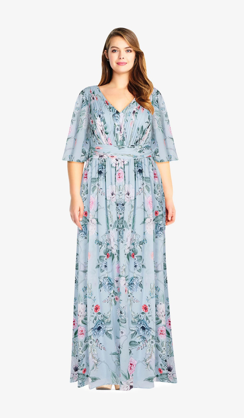 Plus-size model wearing floor-length dusty blue floral print maxi with dolman sleeves