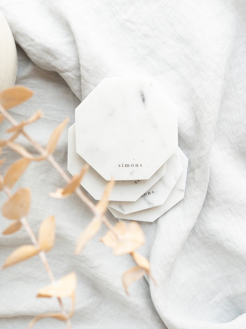 Four stacked minimalist marble coasters personalized with the name Simons