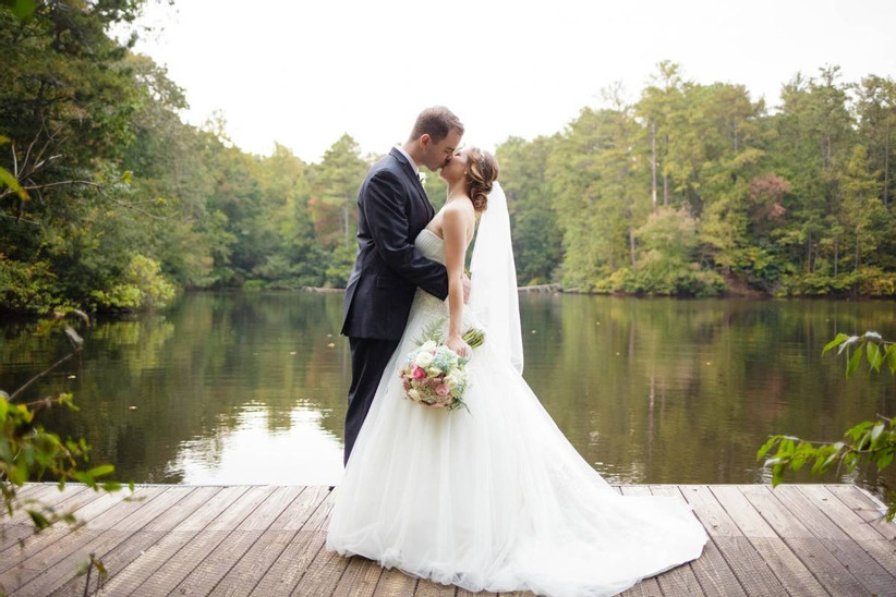 bride and groom kissing on dock