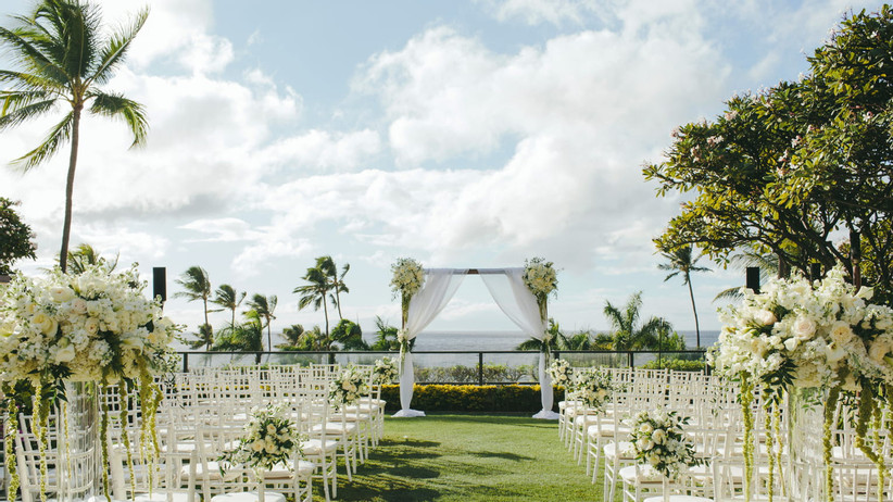 гламурная свадебная церемония на открытом воздухе с маркерами для прохода с белыми розами и стульями из кьявари