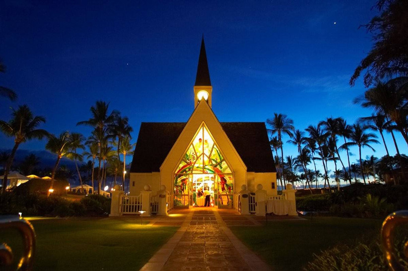 внешний вид часовни, где проводятся свадьбы, освещается ночью в окружении пальм и звезд на небе 