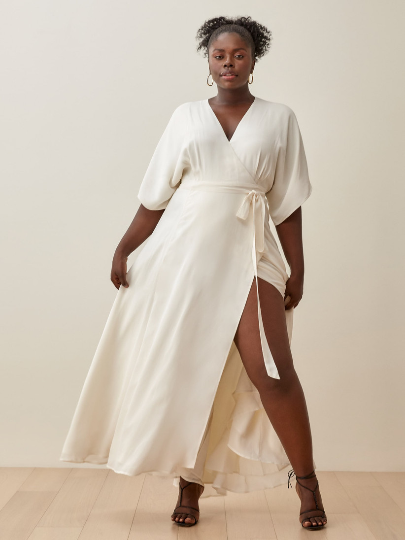 Model wearing minimalist off-white ankle-length wrap wedding dress
