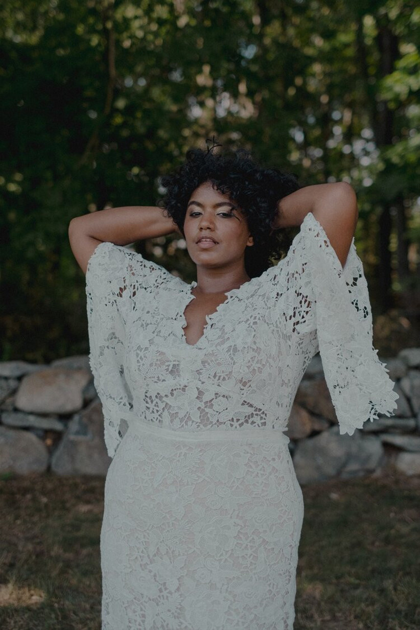Model wearing lacy boho-style wedding dress