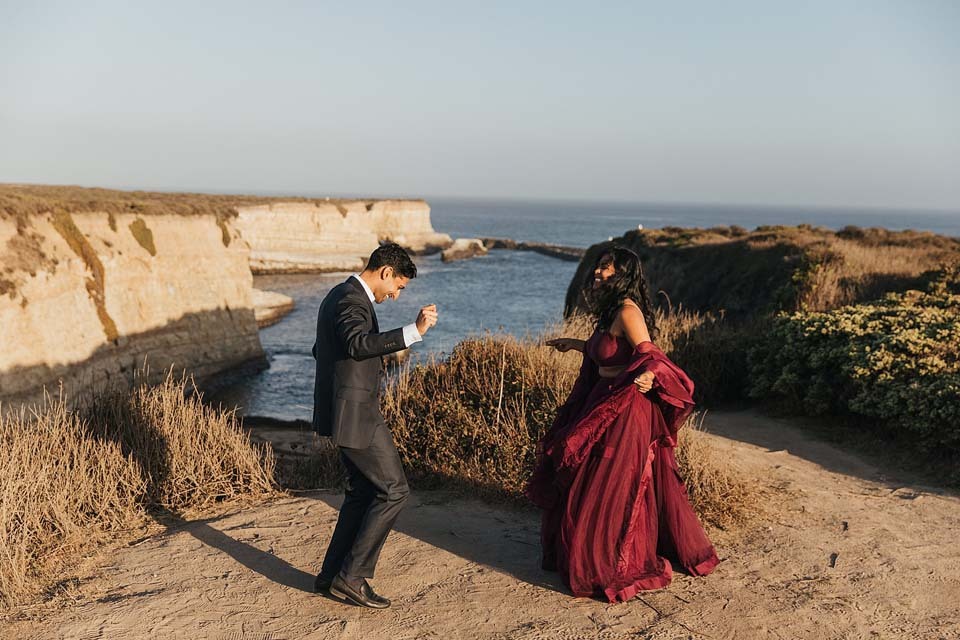Пара танцует на берегу океана сразу после помолвки