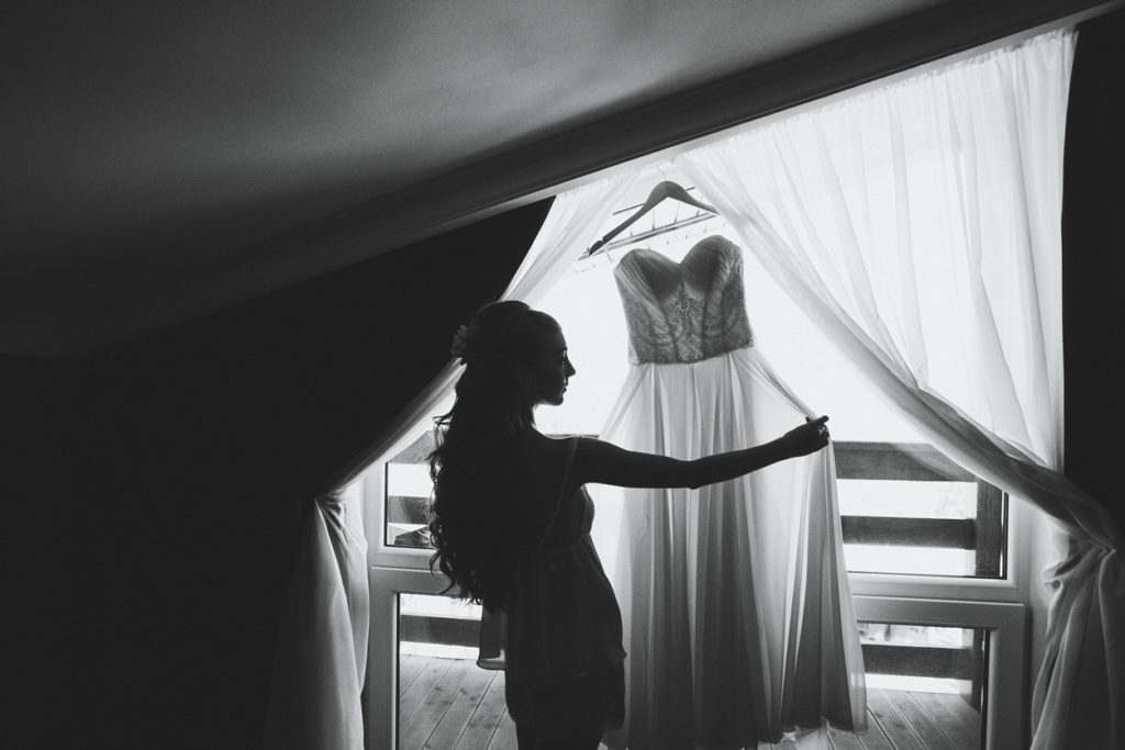 невеста смотрит на свадебное платье