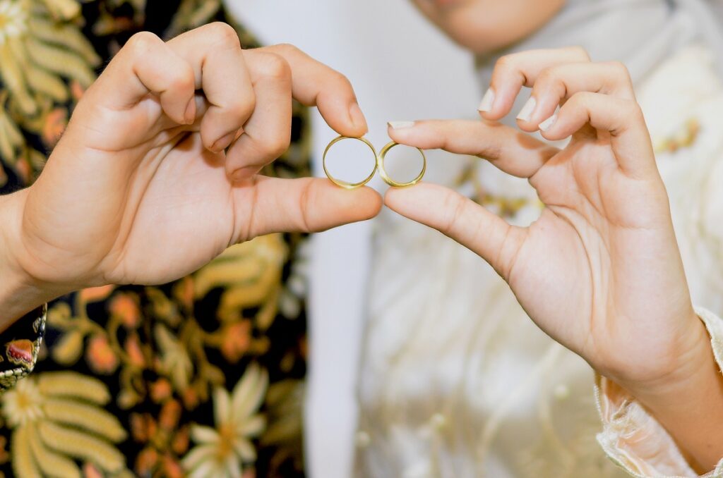 обручальные кольца в руках жениха и невесты